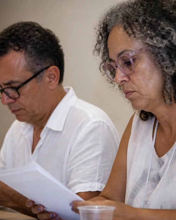 Grupo sentado numa sala clara enquanto uma pessoa defende um ponto de vista